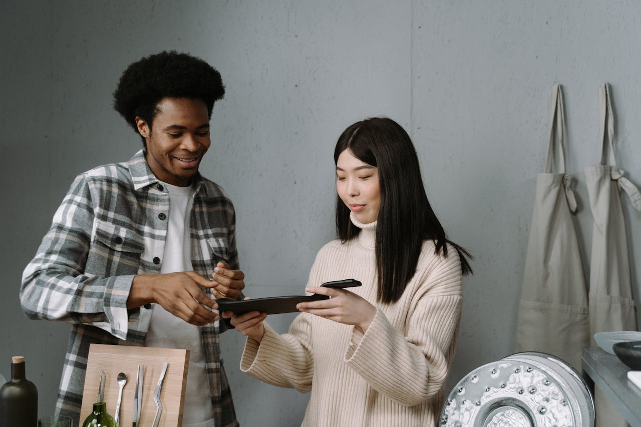 Man selling his products by demonstrating to the woman on his tablet